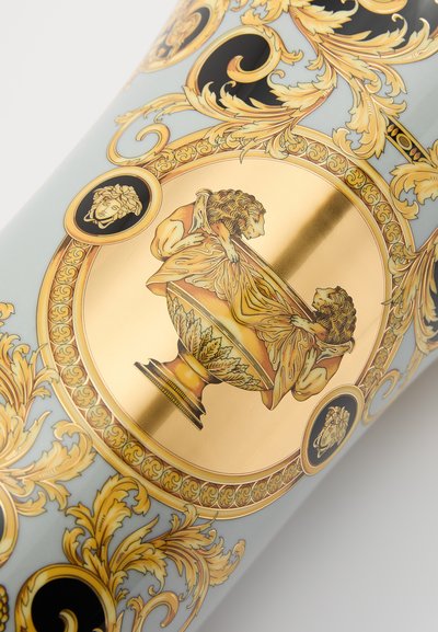 Vaso de cerâmica com design intrincado em dourado e preto, apresentando motivos ornamentais e imagens detalhadas de leões e uma ânfora clássica.