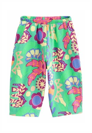 Shorts à taille élastique verte avec de grands motifs floraux colorés et des motifs abstraits en rose, violet, bleu et beige sur un tissu texturé.