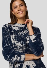 Marineblauer und grauer Strickpullover mit flauschiger Textur, versehen mit einem grafischen Muster und rundem Ausschnitt. Lange Ärmel mit gerippten Bündchen.