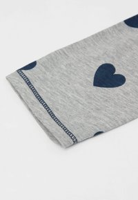 Šedá tkanina s námořnickým srdcovým vzorem; má ohnutý manžet s kontrastním švem. Měkká textura, ležérní design.