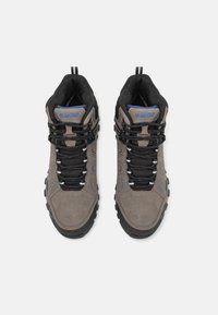 Braune Wildleder-Wanderschuhe mit schwarzen Mesh-Akzenten, strukturierten Details, schwarzen Gummisohlen und blauen Markenlogos auf der Zunge und den Seiten.