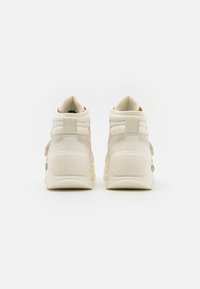 Högstövlar i off-white mesh och mocka, med en strukturerad yta, vadderat ankelskydd och gummisulor med logotypdetalj.