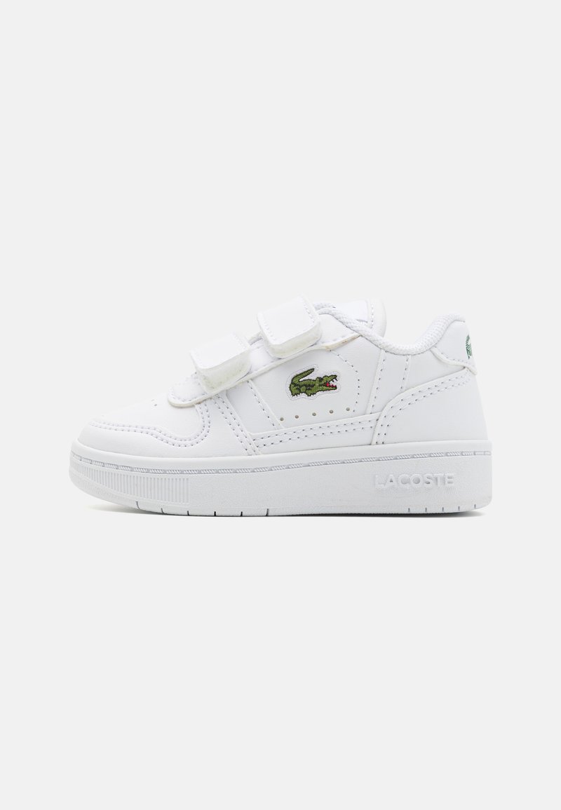 Fehér sneaker, két tép�őzáras pánttal, sima szintetikus felsőrésszel, alacsony profilú dizájnnal, domború logóval a sarkán, és zöld krokodilkép emblemmel az oldalán.