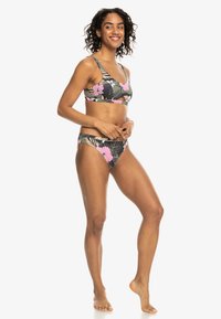 Bikini-set med blommigt mönster som har en mörk bakgrund med rosa blommor. Toppen har breda axelband och trosorna har klassisk skärning med sidodetaljer.