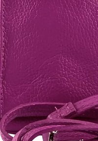 Fuchsia leren handtas met een gestructureerde afwerking, voorzien van een lange schouderband, platte bodem en details van topstiksel. Compacte en rechthoekige vorm.