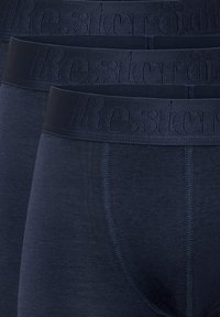 Navyblaue Unterwäsche mit weicher Textur und elastischem Bund, auf dem der eingeprägte Markenname "Resteröds" zu sehen ist. Drei Paare werden präsentiert.