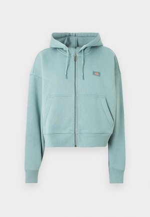 Ανοιχτό μπλε φούτερ με φερμουάρ, εμπρόσθιες τσέπες, κουκούλα με κορδόνι και μικρό ορθογώνιο λογότυπο στο στήθος.