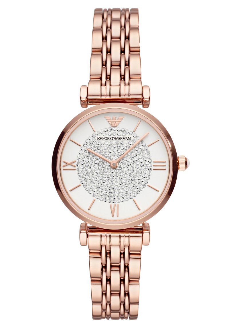 Reloj redondo con una correa de metal de oro rosa y una esfera blanca texturizada que presenta un círculo adornado con cristales y marcadores de números romanos.