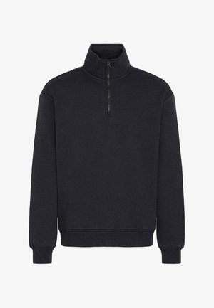 Svart fleece genser med kvart-glidelås krage, lange ermer, ribbestrikkede mansjetter og nederkant. Glatt tekstur og minimalistisk design.