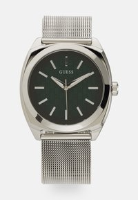 Reloj con dial verde estampado, correa de malla de plata y caja de acero inoxidable pulido. Presenta indicadores de horas simples y dos manecillas plateadas.