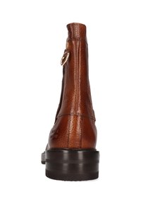 Bota de tobillo de cuero marrón con acabado texturizado, detalle de anillo dorado cerca de la parte superior y tacón oscuro apilado, vista desde atrás.