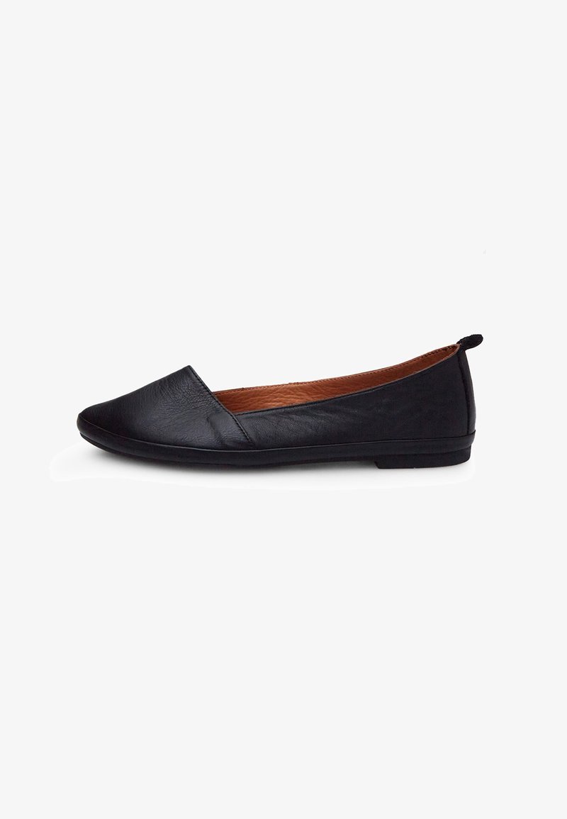 Zapato plano de cuero negro con puntera afilada, textura suave, perfil bajo y una pequeña solapa trasera; el interior presenta un revestimiento marrón.