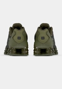 Sorte og olivengrønne sportssko med mesh-overdel, teksturerede detaljer og en klumpet gennemsigtig gummisål. Har polstret hæl og logo-detalje.