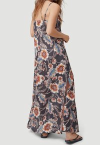 Maxi sukienka w kwiatowy wzór w ciemnych kolorach, z cienkimi regulowanymi ramiączkami, bocznymi rozporkami oraz lekkim materiałem, który tworzy zwiewną sylwetkę.