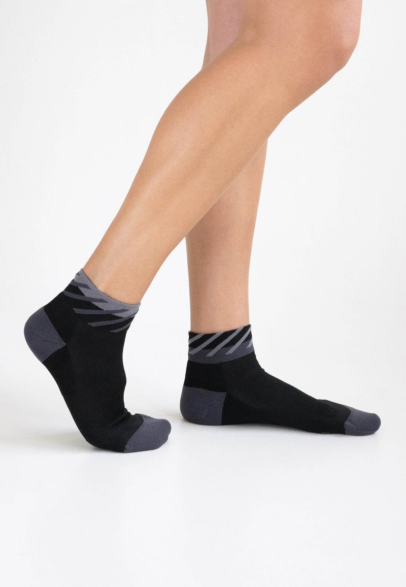 Schwarze und graue Knöchelsocken mit einem strukturierten Muster am Bündchen sowie verstärkten Zehen- und Fersenbereichen für Langlebigkeit.
