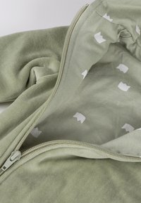 Hellgrüner Kapuzenpullover zum Hochziehen mit weicher Textur und gemustertem Innenfutter mit kleinen weißen Formen. Sichtbare Reißverschlussbeschläge.