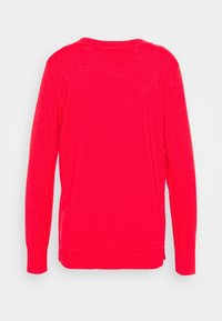 Roter Pullover mit langen Ärmeln, geripptem Ausschnitt und Bündchen. Weiche Textur, abgerundeter Saum und seitliche Schlitze für bessere Bewegungsfreiheit. Schlichtes Design.