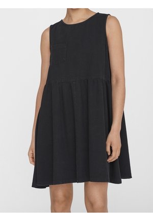 Robe noire sans manches avec une petite poche poitrine et une taille froncée, portée par une personne sur un fond clair uni.