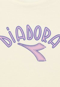 Maglietta color crema chiaro con testo viola audace che recita "DIADORA", con una freccia rosa stilizzata come parte del design.
