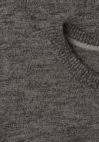 Gros plan d'un pull en maille gris montrant un tissu texturé et une encolure ronde côtelée.