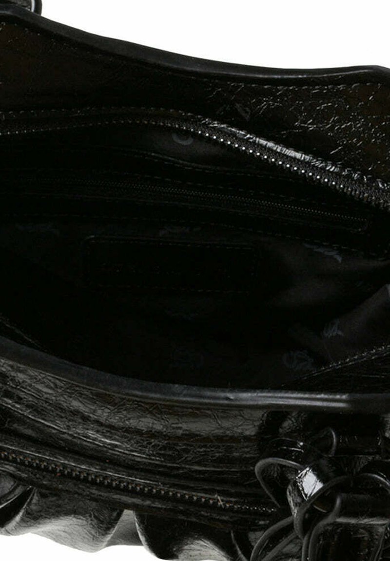 Intérieur d'un sac à main en cuir verni noir avec un compartiment zippé et une doublure lisse. Détails avec un bord froncé et un éclat subtil.