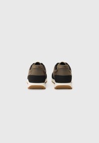 Sport shoes with a black and olive green upper, cushioned insole, white midsole, and a rubber outsole. Features HUGO branding on the heel.