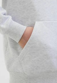 Hellgrau Sweatshirt mit geripptem Bündchen und einer Fronttasche. Der Stoff hat eine weiche Textur mit einem dezenten melierten Muster.