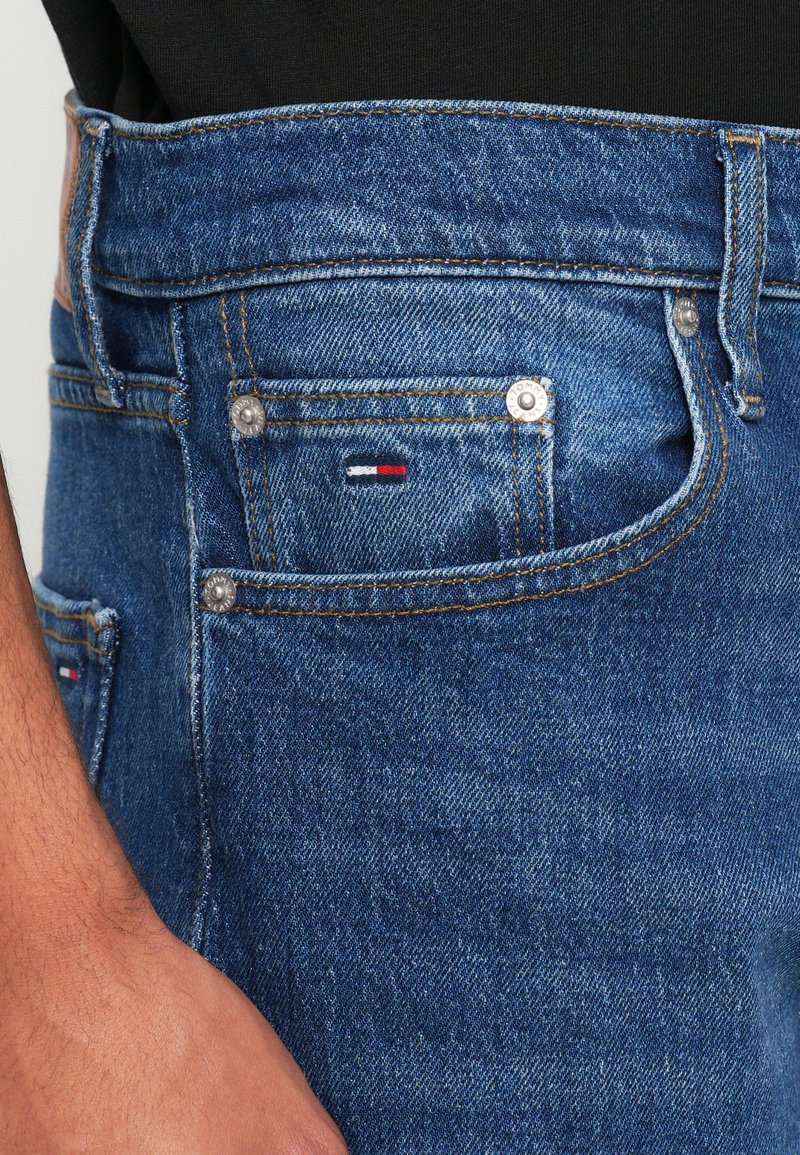 Blå denimjeans med en klassisk pasform, fem lommer, kobberbeslag og et lille stribet logo på frontlommen.