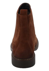 Stivaletti alla caviglia in suede marrone con punta arrotondata, inserti laterali elastici e tacco basso a blocco. Presentano cuciture decorative e una suola texturizzata.