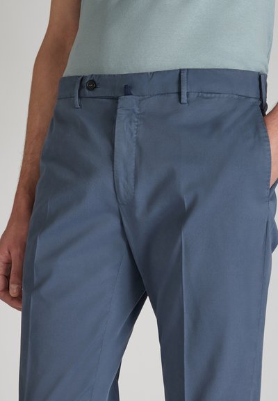 Pantaloni su misura da uomo in un tessuto blu scuro. Presentano una parte anteriore liscia, tasche laterali e una superficie uniforme. Comprendono una chiusura con bottone.