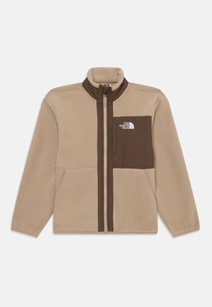 Beige Fleecejacke mit braunen Akzenten, hohem Kragen, durchgehendem Reißverschluss und einer Brusttasche. Mit dem weißen Logo von The North Face.