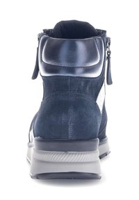Marineblauwe suède enkellaars met een gestructureerde afwerking, voorzien van een metallic rits en een grijze rubberen zool. Accent van glad leer op de hak.