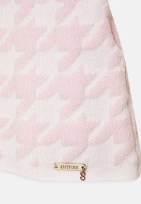 Borsa rosa con un motivo houndstooth testurizzato, con una placca del logo "Guess" in oro e dettagli decorativi.