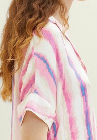 Blusa a manica corta in tessuto morbido con un motivo marmorizzato nei toni del rosa, blu e bianco. Texture morbida con polsini arrotolati e una vestibilità rilassata.
