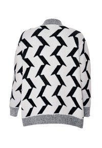 Maglione bianco e nero con motivo a zigzag, texture a maglia, colletto e polsini a coste grigi, vestibilità ampia, dettagli di cucitura visibili.