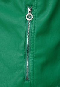 Grüne Lederjacke mit einem silbernen Metallreißverschluss und einem runden Zipper, der eine strukturierte Oberfläche und präzise Nähte aufweist.