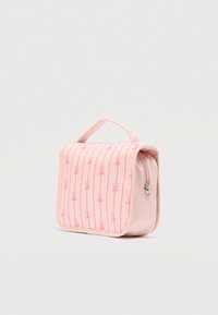 Ροζ υφασμάτινη τσάντα με φερμουάρ, διακοσμημένη με μοτίβο γραμμών που σχηματίζουν ψαλίδια. Συμπαγές σχήμα, επίπεδες πλευρές και κοντό χερούλι για εύκολη μεταφορά.