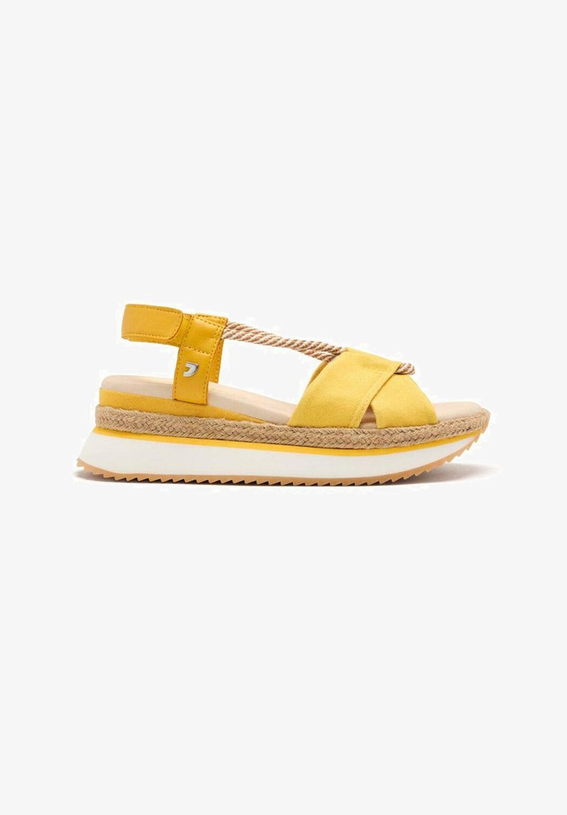 Sandales compensées jaunes avec des brides croisées en tissu, semelle de style espadrille et une semelle intermédiaire blanche. Détails en corde texturée sur la bride.