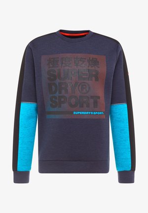 Sweat bleu marine avec manches noires et bleu vif, avec le texte "SUPERDRY SPORT" et des caractères japonais en noir et rouge sur le devant.