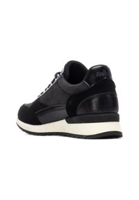 Zapatilla negra hecha de ante y cuero, con un cuello acolchado, entresuela blanca, tacón texturizado negro y detalles de costuras en contraste.