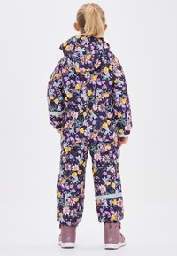 Kindersneeuwpak met bloemenpatroon in paars, voorzien van een capuchon, elastische manchetten en details met reflecterende stroken. Gelaagd materiaal met levendige kleuren.