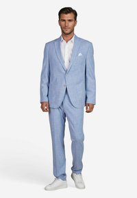 Lichtblauw geruit pak met een getailleerd ontwerp, wit dress shirt en witte sneakers. Opvallende details zijn een borstzakdoek.