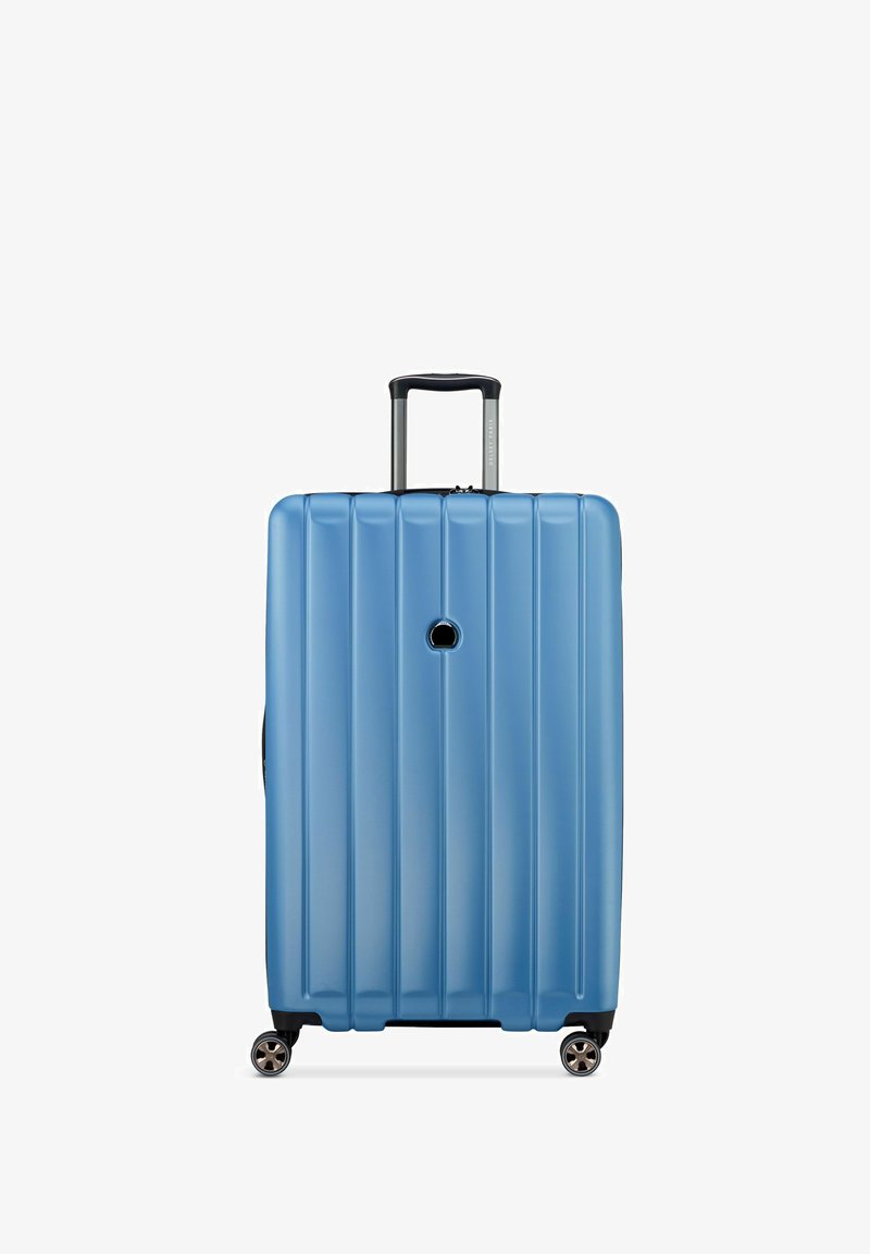 Maleta rígida de color azul claro con estrías verticales, asa retráctil y cuatro ruedas para una fácil maniobrabilidad.