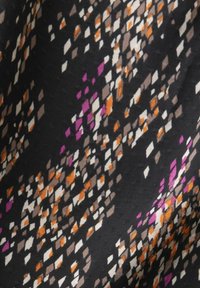 Tissu noir avec un motif dispersé de losanges en orange, violet, blanc et gris.