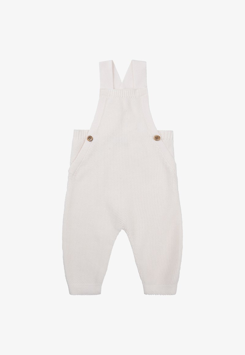 Witte gebreide salopettes met verstelbare banden, twee voorzakken en houten knopenaccenten. Textuurstof met geribbelde details.