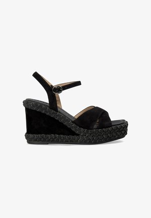 Sandalias de cuña negras con parte superior de ante suave, correa ajustable con hebilla y suela de esparto trenzada texturizada.