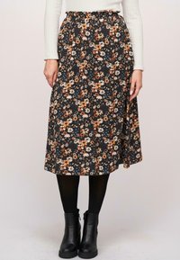 Fustă neagră cu flori, având flori portocalii și albastre, talie elastică, lungime midi, material moale, asortată cu botine negre.