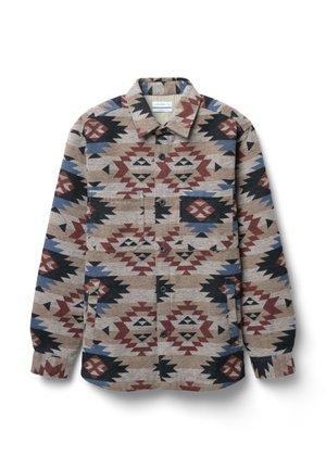 Woven button-up jacket in beige, featuring geometric patterns in red, blue, black, and brown; includes two front pockets and a collared neckline.