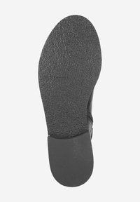 Semelle de chaussure noire avec surface texturée, bout arrondi et talon léger. Présente un bord lisse et un design minimaliste.