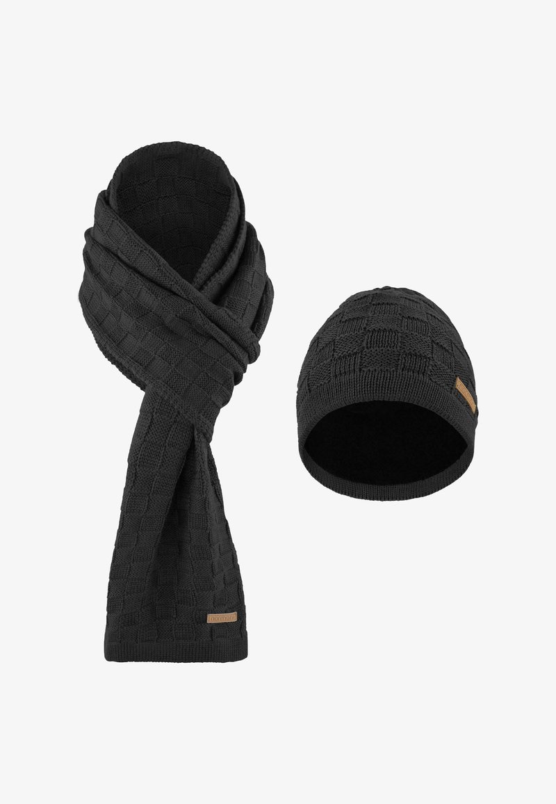 Black knitted scarf and beanie set, featuring a textured square pattern and a soft lining. Scarf is long with a twisted design; beanie fits snugly.